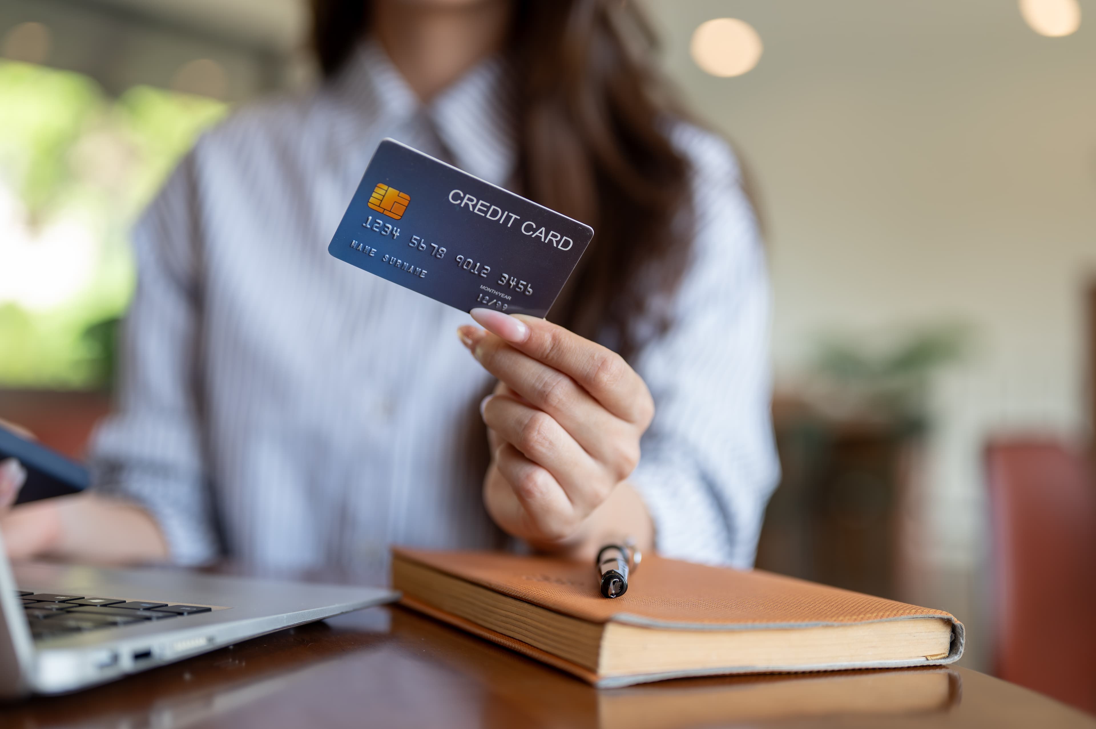 Person holding a credit card while shopping online